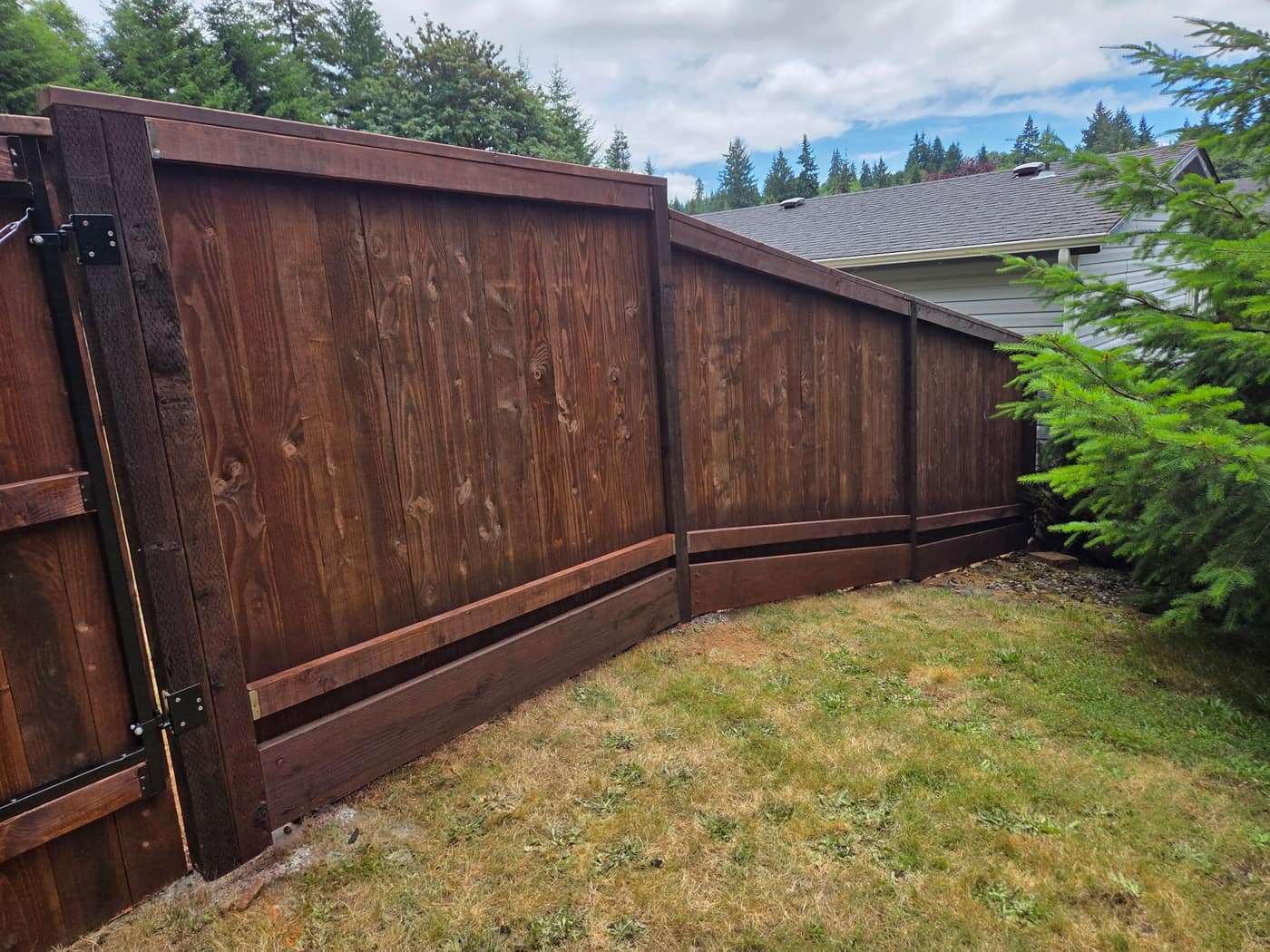 Base of a cedar fence showing the kick board and post bottoms, the area to inspect before staining, Portland OR