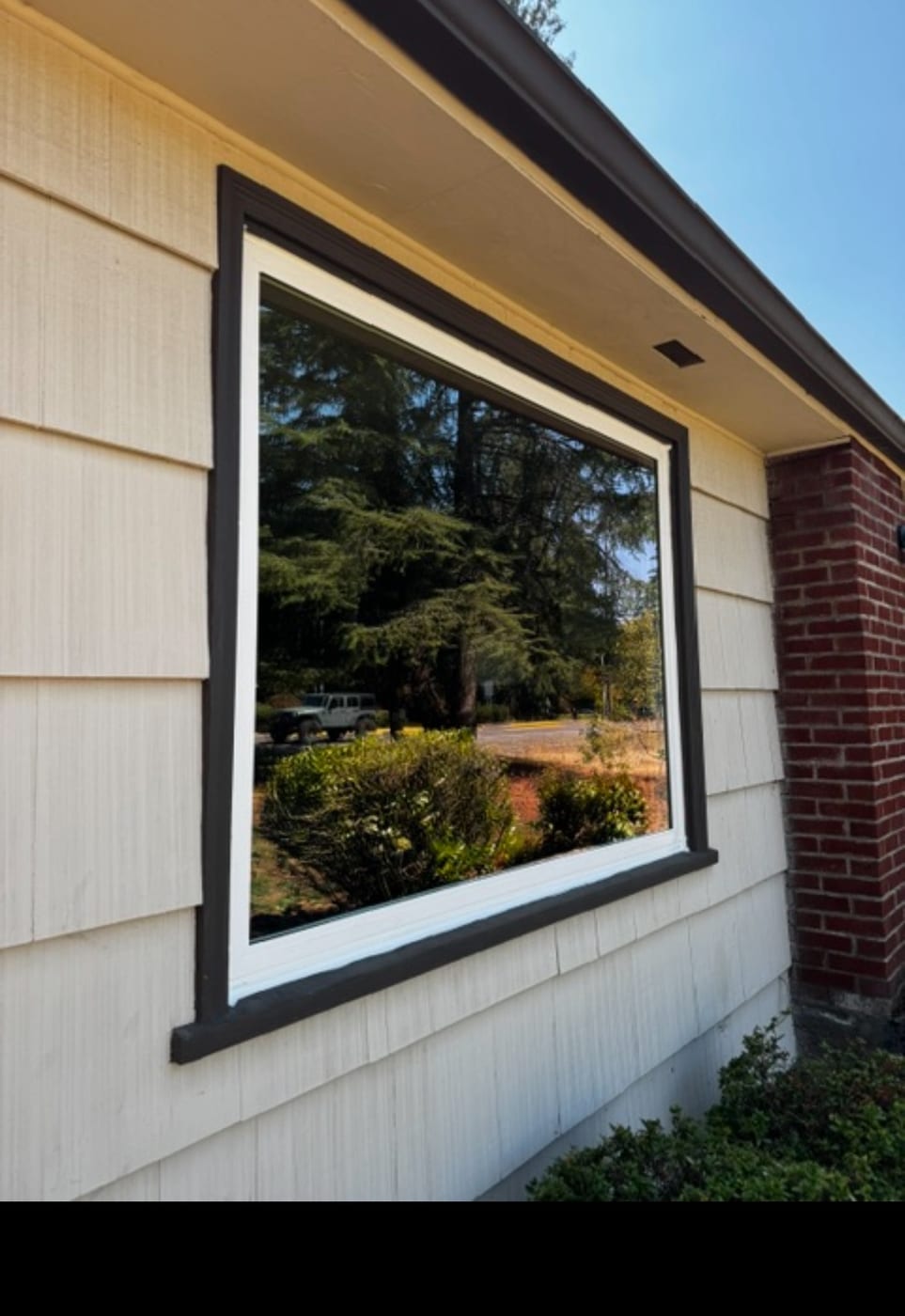 Finished Milgard vinyl picture window with black exterior trim installed on a Portland, OR area home