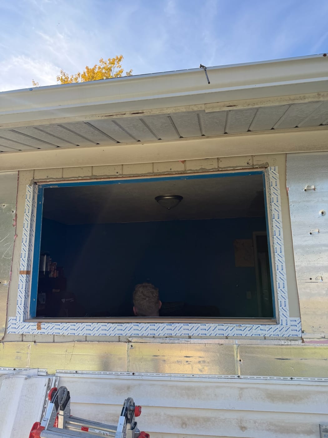 Full-frame window replacement in progress on a Portland, OR home, old window removed to the rough opening with new flashing tape around the frame