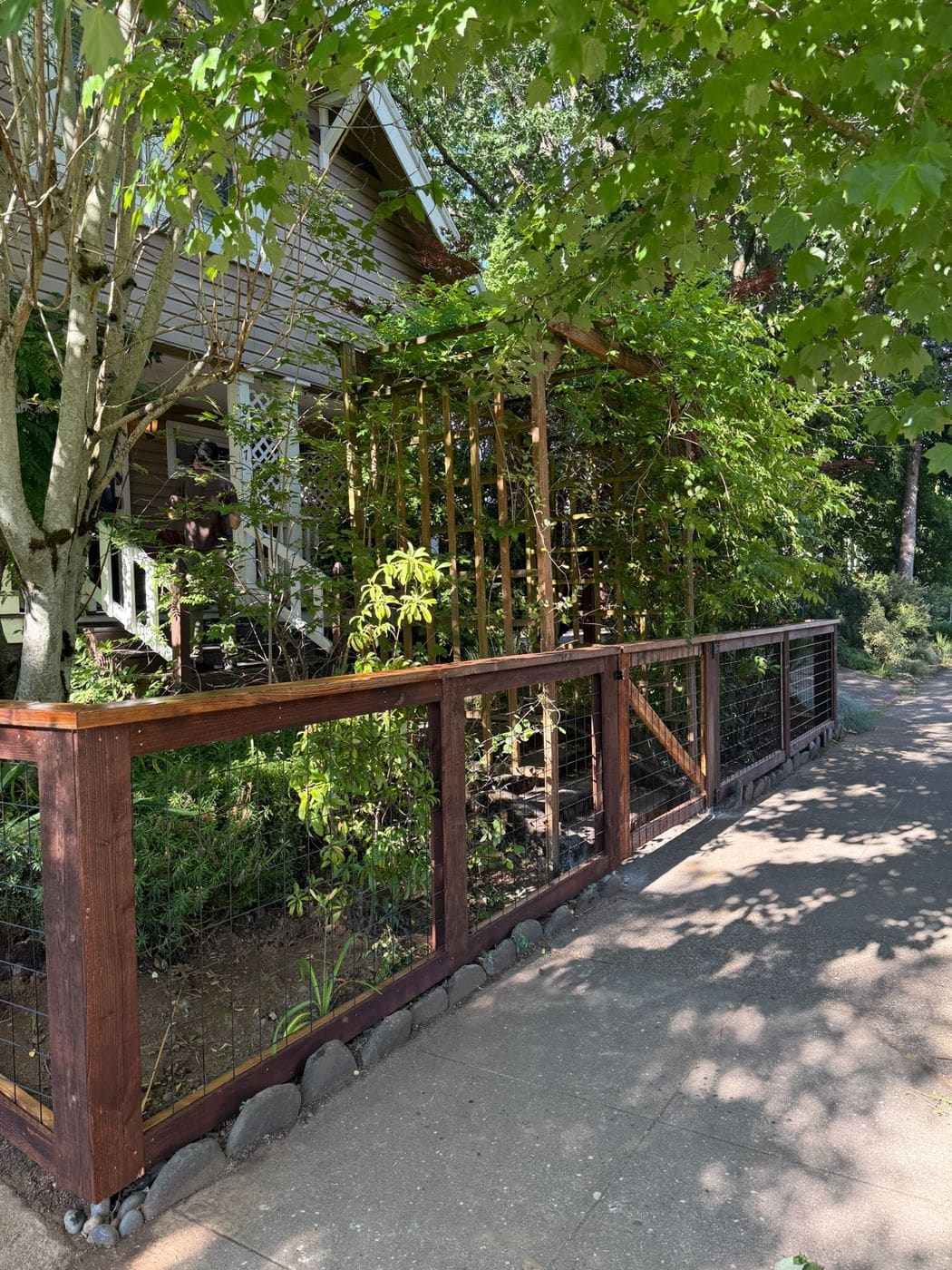 Hogwire fence with a stained wood frame and welded wire panels installed by Gorilla Works in the Portland, OR area