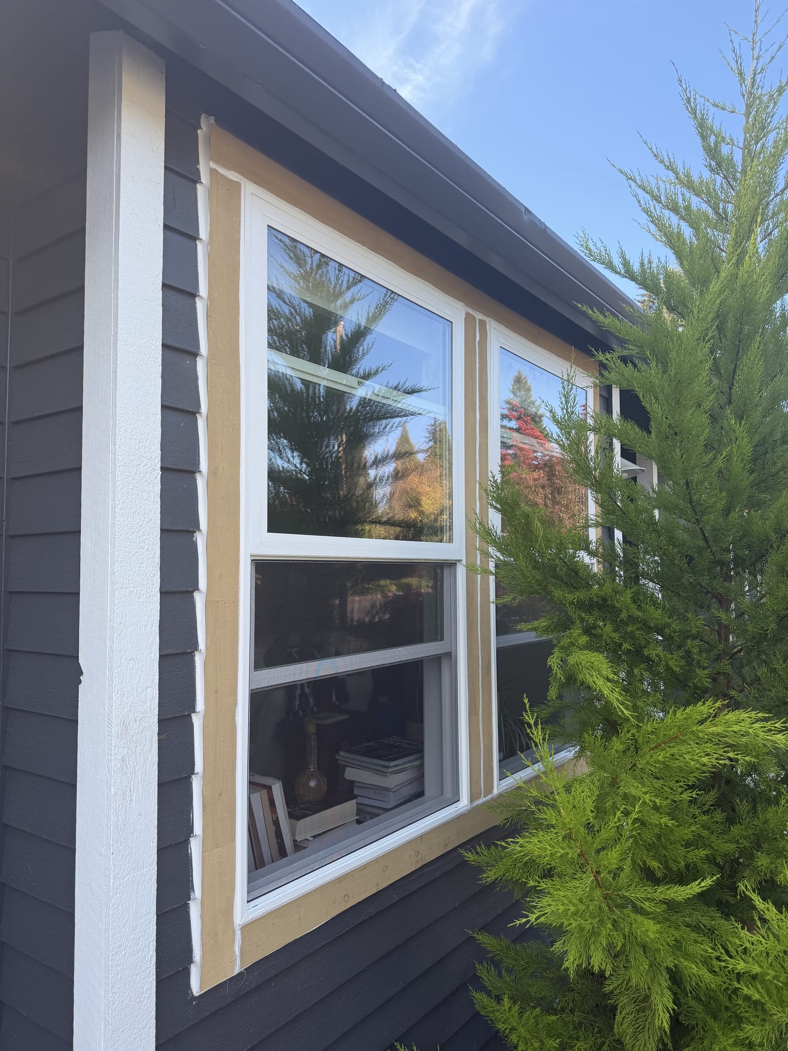 New white vinyl hung windows set in fresh trim on a dark-sided Portland area home, a Gorilla Works install