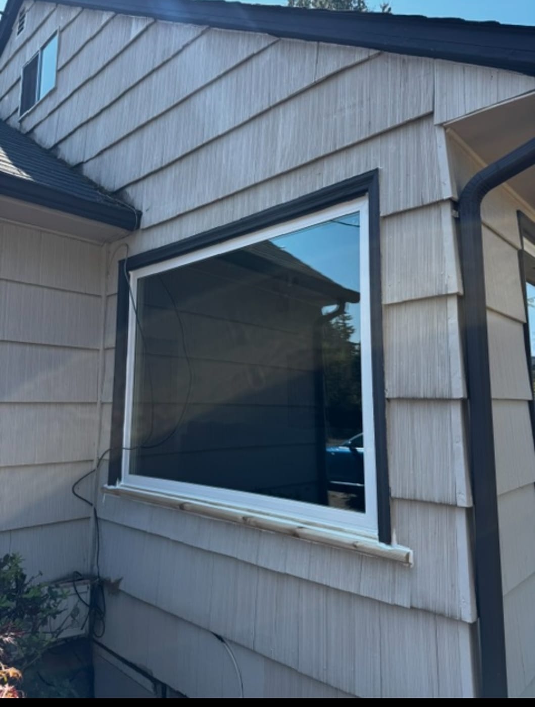 New Milgard vinyl window with black trim on a cedar-sided Portland, OR home