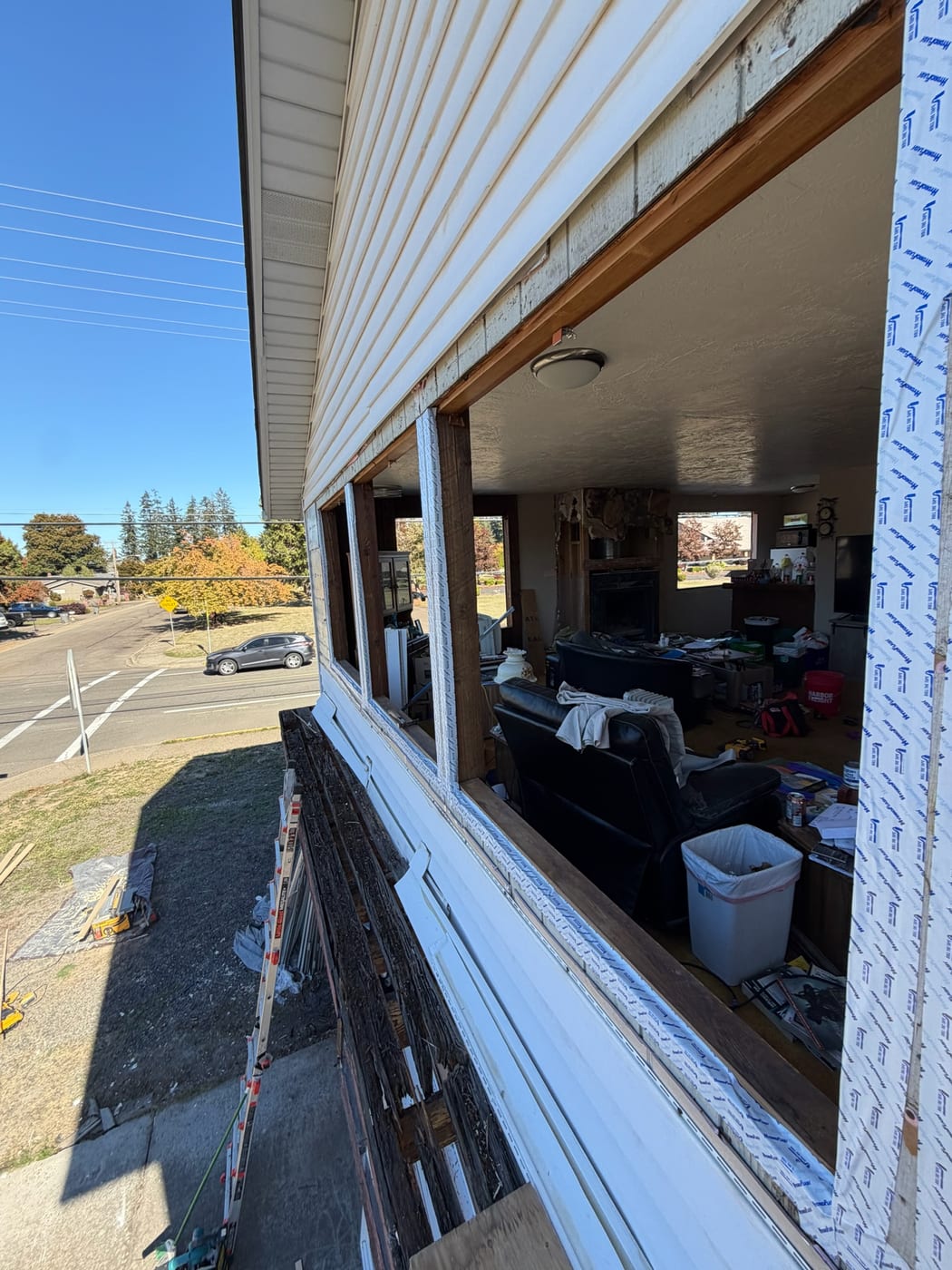 Full-frame window tear-out on a Portland, OR home, the old window bank removed down to the rough opening with the framing and new flashing exposed