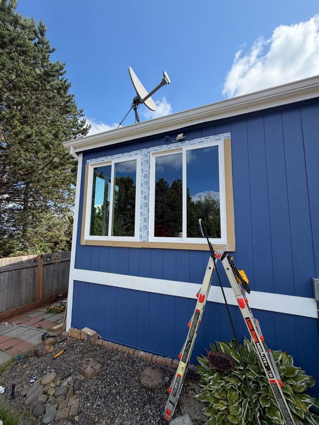 New white vinyl windows installed in a Portland OR home, flashing tape still visible around the opening mid-install
